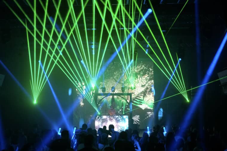 DJ auf der Bühne des Elektroevents Amphoria Im Hintergrund eine LED-Wand und Scheinwerfer.